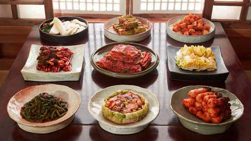 una mesa con nueve platos de diferentes formas y con diferentes tipos de comida