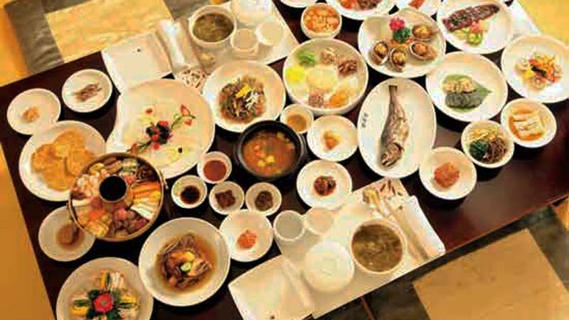una mesa con muchos platos con todo tipo de comida