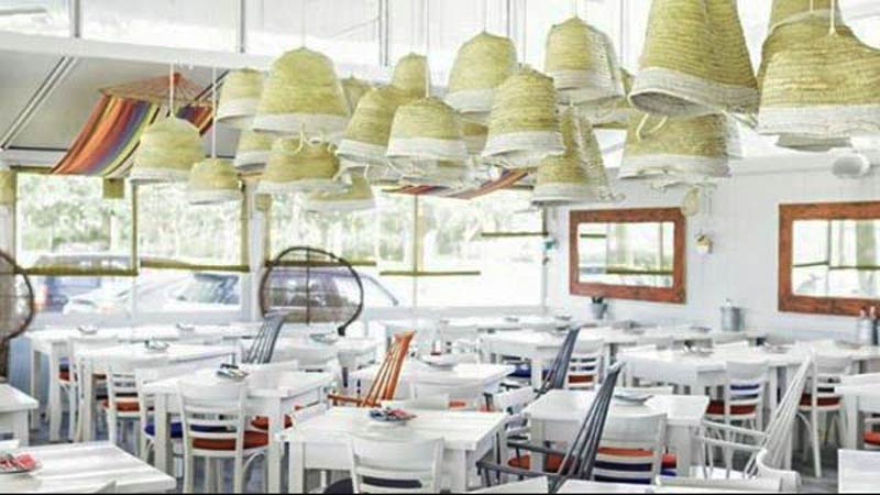 restaurante con mesas blancas y lámparas colgantes