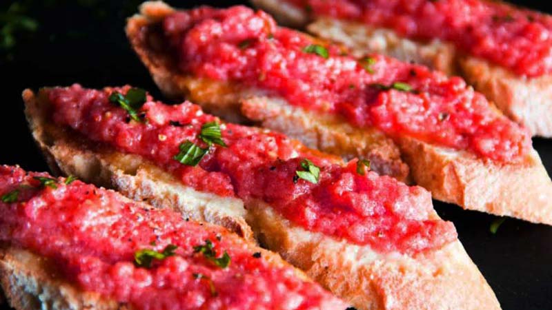 unas rebanadas de pan con tomate natural encima