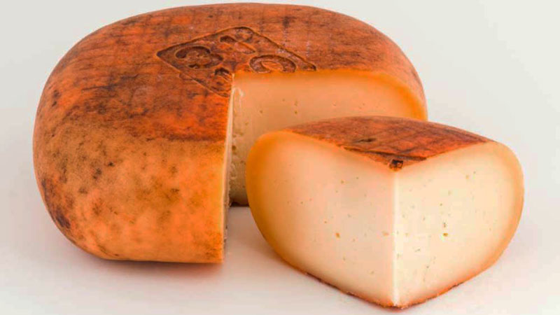 queso curado con un cuarto cortado que está al lado