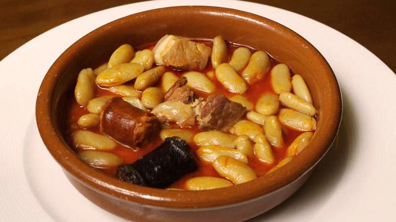 una bandeja de barro con judías y chorizo