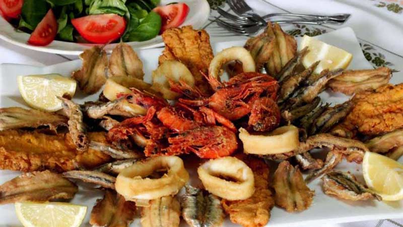 bandeja blanca con pescado rebozado y marisco