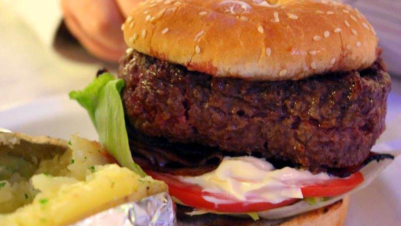 una hamburguesa con carne gruesa con salsa