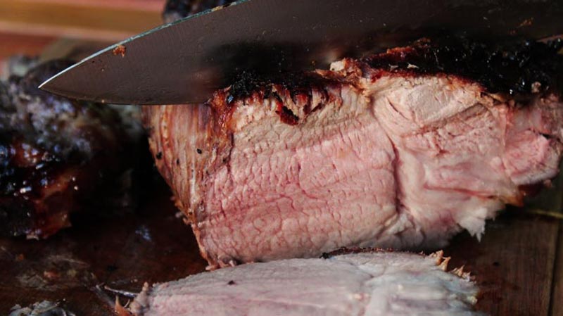 un cuchillo cortando un trozo de carne asada