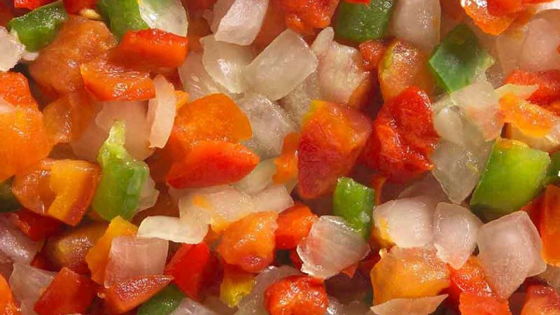 trozos de hielo mezclado con trozos de tomate y pimientos