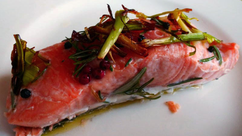 filete de salmón con verduras en un plato blanco