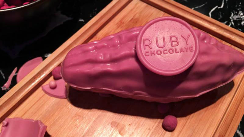 una tabla de madera con fragmentos de chocolate de color rosa