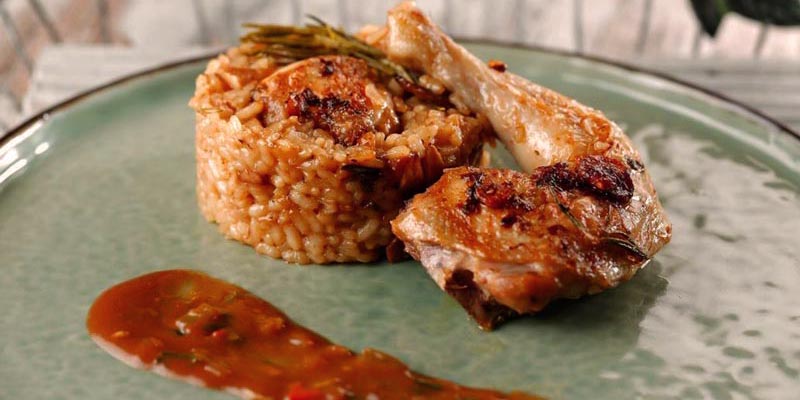 arroz con una pechuga de pollo con un poco de salsa al lado