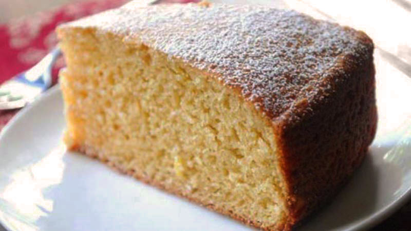 plato blanco con una porción de bizcocho con azúcar por encima