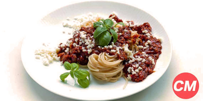 plato blanco con espaguetis con hojas y salsa boloñesa
