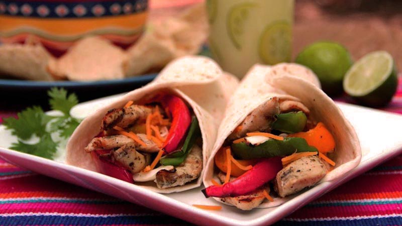 burritos con carne y pimientos sobre un plato cuadrado