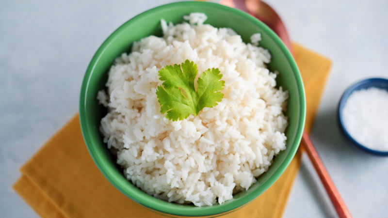 bol verde con arroz blanco y una hoja verde encima