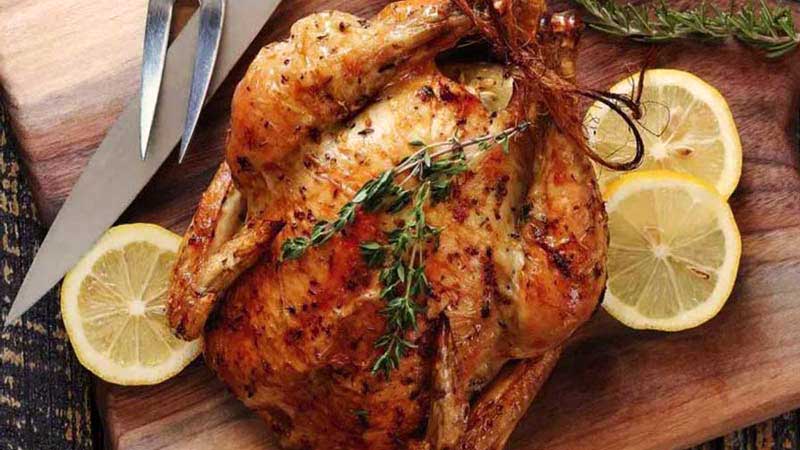 pollo con especias y con tres rodajas de limón al lado