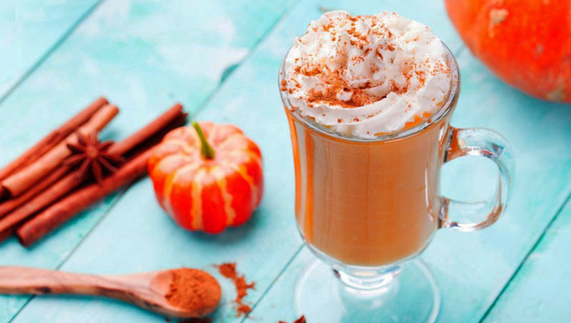 copa con nata y una calabaza pequeña en la izquierda sobre una mesa azul