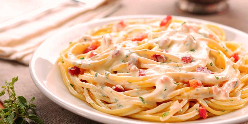 plato blanco con espaguetis con salsa carbonara