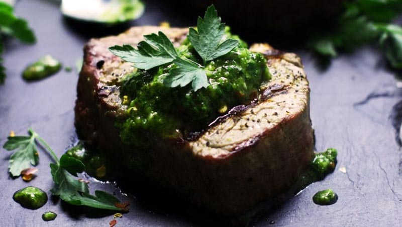 un filete de solomillo con salsa verde y hojas