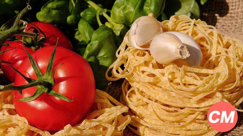 espaguetis con ajos encima y tomates en la izquierda curiosidades sobre la pasta