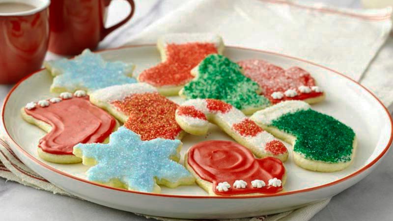 plato blanco con el borde rojo que tiene galletas de navidad con formas como árboles, calcetines o copos de nieve-recetas de Navidad