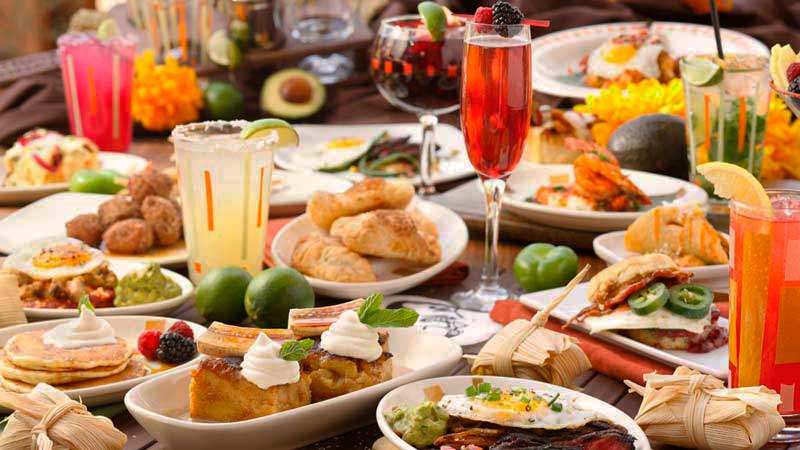 una mesa repleta de platos y vasos con todos tipo de comida como croquetas, tortillas, tortillas y carnes