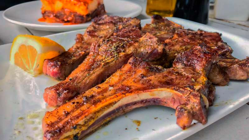 costillas en un plato blanco rectangular con un trozo de limón en la izquierda