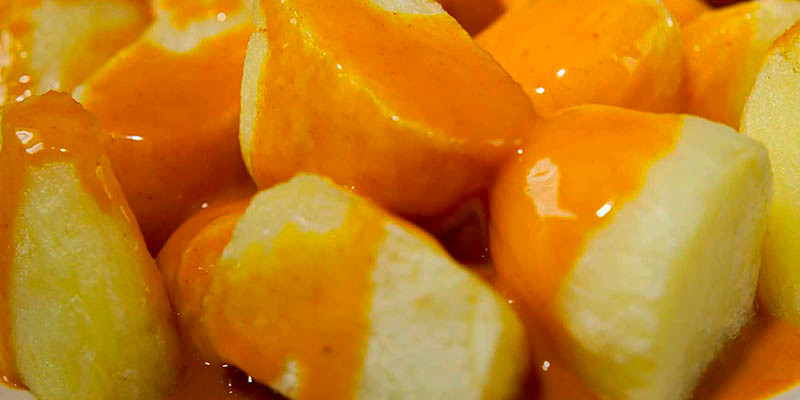 plano detalle de patatas con salsa brava por encima