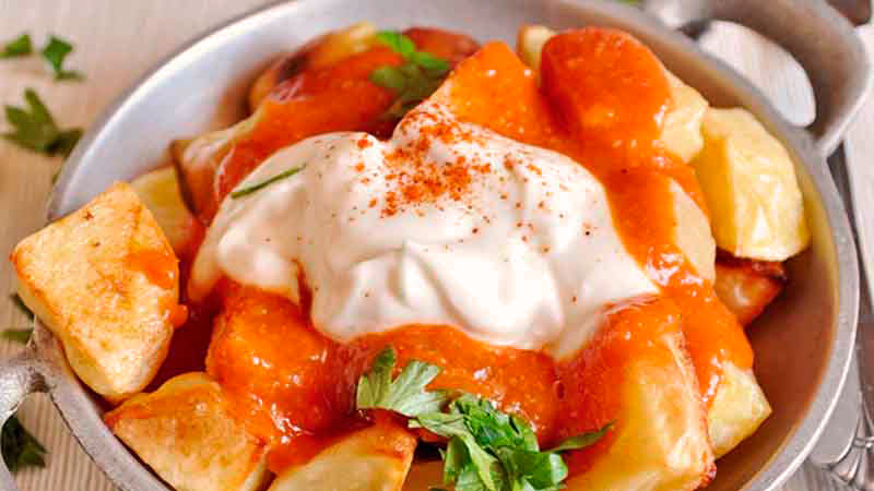 cacerola metálica pequeña con patatas con salsa brava y mayonesa