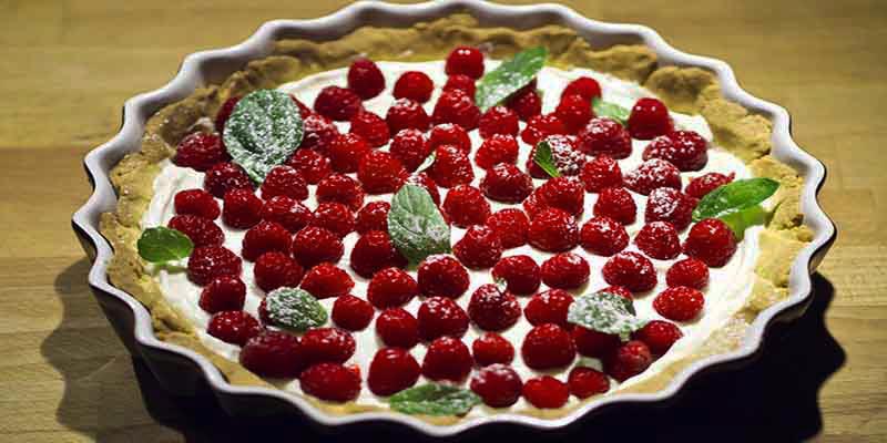 tarta dentro de un molde ondulado y con frutos rojos dentro