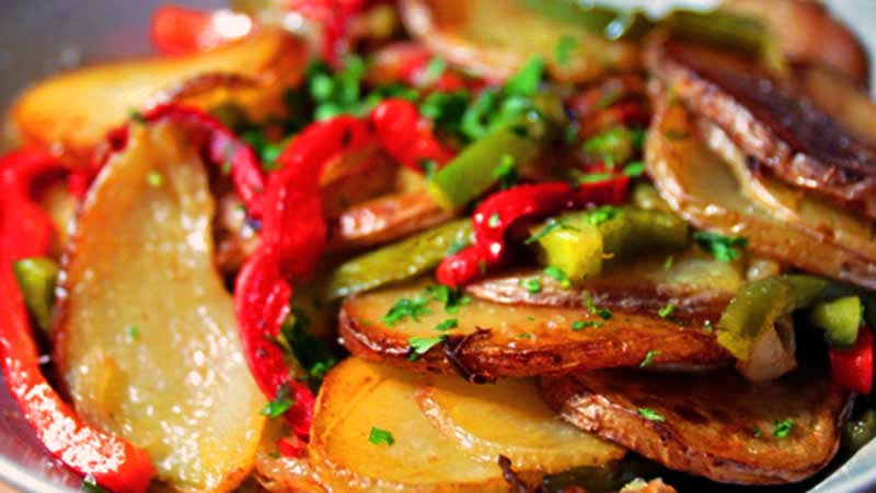 láminas de patatas con pimientos verdes y rojos cortados en tiras