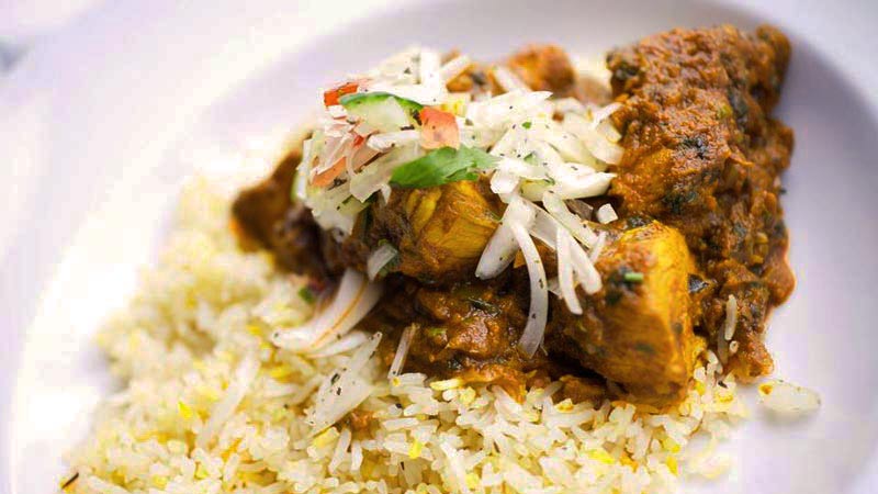 plato blanco con arroz y piezas de pollo con curry y cebolla