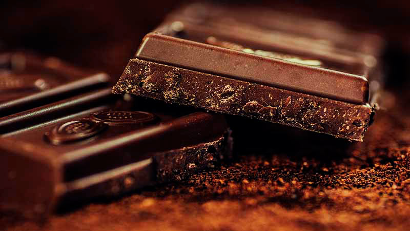 dos tabletas de chocolate, una encima de la otra y con el fondo desenfocado