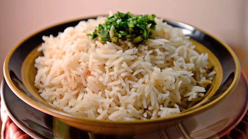 arroz con verdura encima y en un plato de tonalidades oscuras