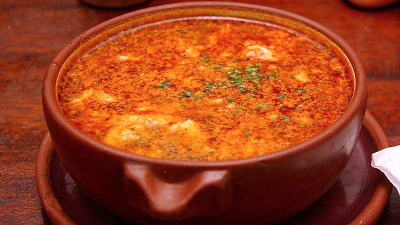 plato de barro con sopa sobre un plato también de barro