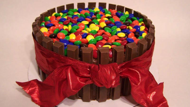 tarta con kit kats y lacasitos,a demás de un lazo rojo