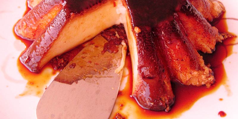 flan con un trozo cortado y con un utensilio metálico