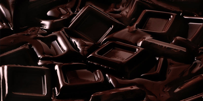 cuadrados de chocolate negro sumergido en chocolate derretido