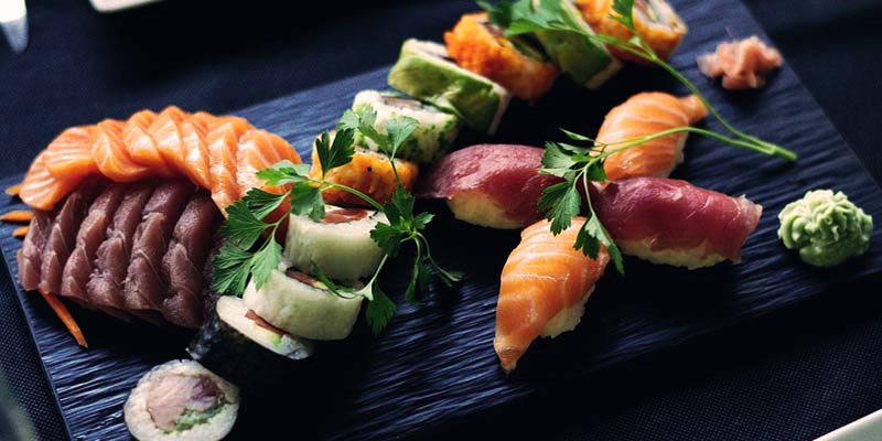 varias piezas de sushi en una tabla azul marino con un fondo del mismo color