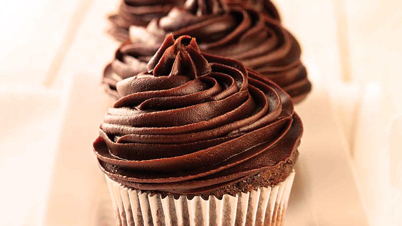 cupcakes en fila con un fondo anaranjado