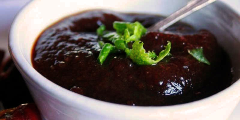 salsa oscura en un bol pequeño blanco y con una cuchara dentro