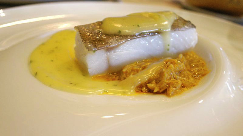 bacalao en salsa amarilla en un plato blanco
