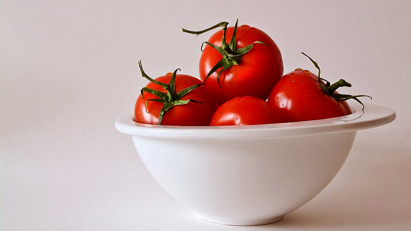 tomates en un bol blanco con un fondo blanco