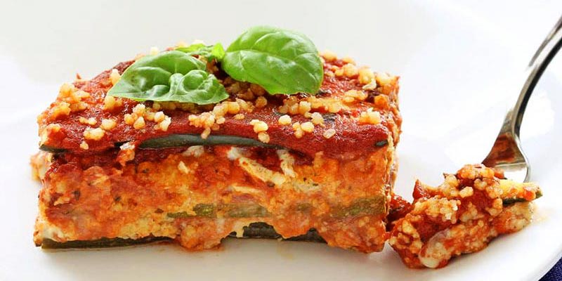 trozo de lasaña con un tenedor al lado
