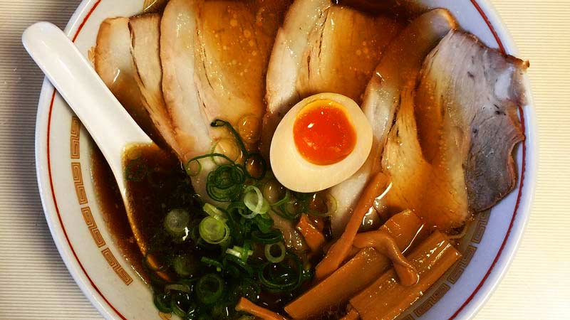 bol con ramen dentro sobre un mantel a rayas finas