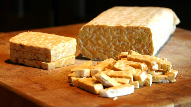 Tempeh cortado en trozos sobre una mesa de madera