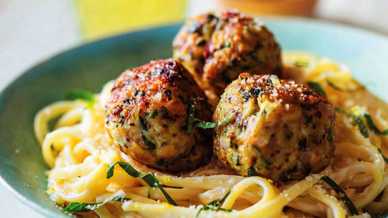 plato verde con espaguetis con tres albóndigas encima
