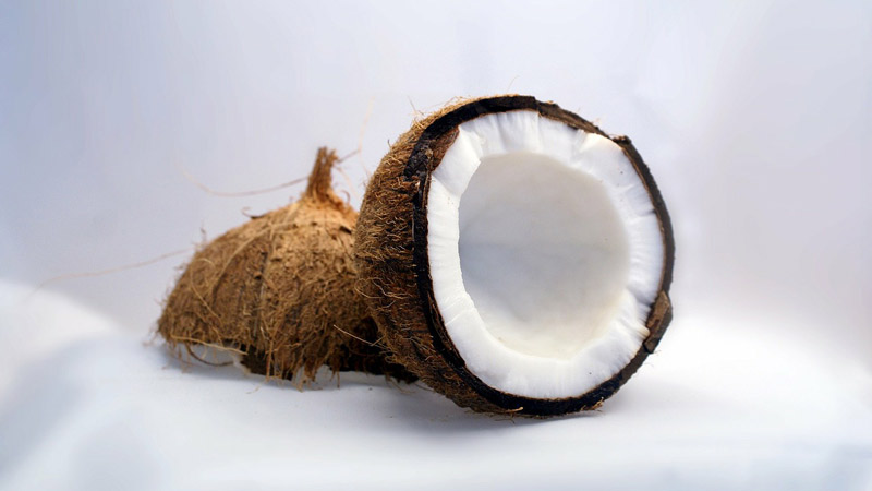 beneficios del coco, coco partido en un fondo blanco