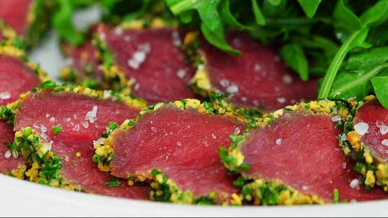 carpaccio rosado con hojas al fondo
