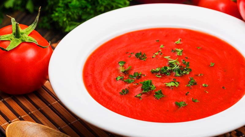 sopa de tomate con perejil en un plato blanco y con un tomate al lado-Recetas con jengibre