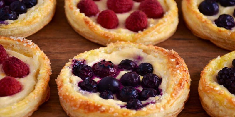 tartas de frutas redondas con frutos rojos sobre madera
