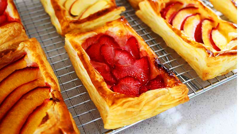 varias tartas de frutas sobre una rejilla de metal